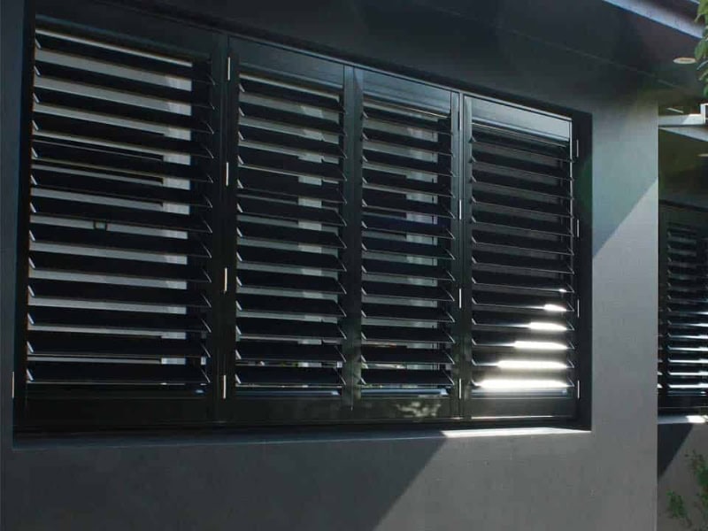 Outdoor shutters for the house featuring modern black louvre panels providing shade, ventilation, and sleek exterior style.